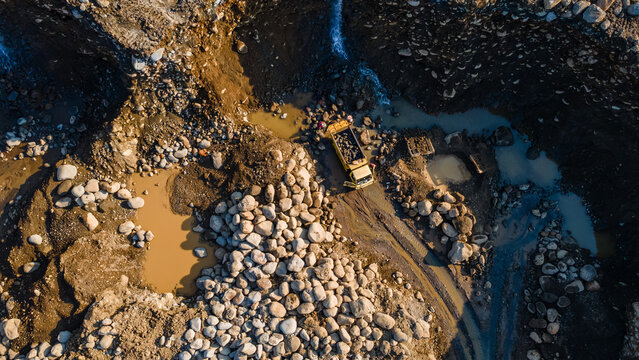 Aerial View of Dump Truck Operating in Active Quarry Mine, Construction and mining site view from above.