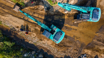 Excavator and Worker Working on Off-Road Construction Project © katakaneh