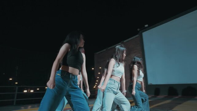 Low Angle Shot of Girl Group Dancing in Unison at Night