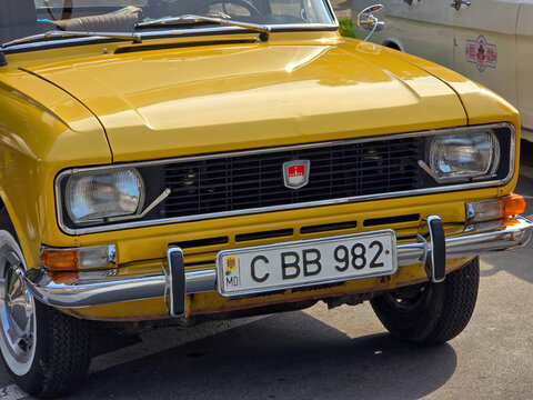 Piatra Neamt, Romania - June 7, 2025: Bright yellow 1982 Moskvitch 2140, a classic Soviet-era car, parked outdoors. The front view highlights its iconic grille and headlights.