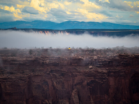 Single light glows in foggy desert canyon landscape