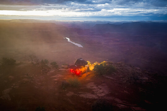 Truck camping on a cliff edge overlooking a canyon