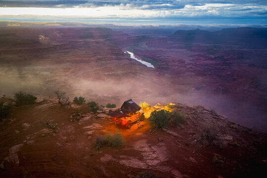 Overland truck with tent camping on a vast canyon rim