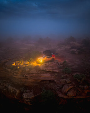 SUV with rooftop tent in a foggy desert at night