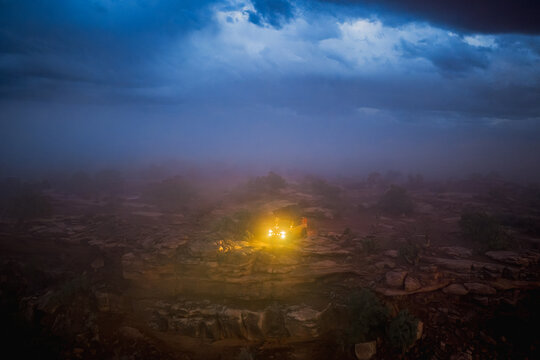 Off road vehicle exploring a foggy desert landscape at night