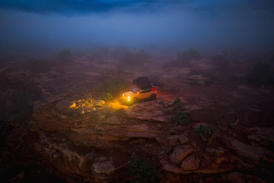 Overlanding vehicle with rooftop tent on a foggy cliff