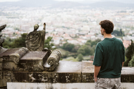 Man at scenic viewpoint overlooking a European city