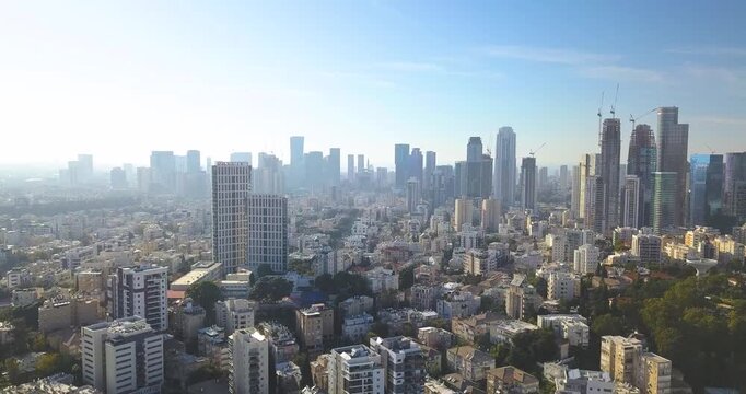 Cinematic drone pull-up shot revealing the skyline of Tel Aviv and Ramat Gan, Israel. The aerial footage showcases dense urban development, modern skyscrapers, business districts, and the iconic metro