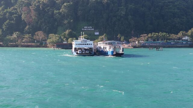 Drone footage of Koh Chang car and passenger ferrys at the main Koh Chang pier. Island travel and transit in a tourist island in Thailand.