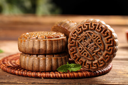 Handmade Mooncakes with Decorative Patterns on Rustic Wood Table