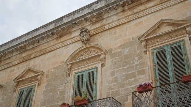 Historic palace in Lecce, Lecce Province, Puglia, Italy, featuring Pietra Leccese limestone, late Baroque ornamentation and Neoclassical window pediments typical of eighteenth and nineteenth century
