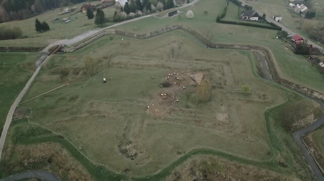 An establishing aerial shot over Jablunkov Fortress reveals ancient settlement earthworks and defensive mounds illuminated by soft morning light.