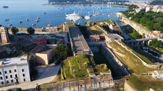 Aerial View of Old Fortress Internal Buildings and Clock Tower in Corfu Town, Greece - Historic Citadel Walls and Harbor with Anchored Yachts