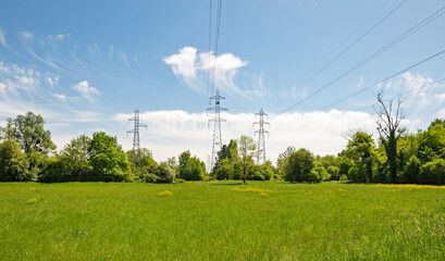 Obraz premium High-voltage power lines above a green meadow in Geispolsheim, France