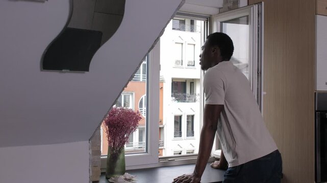 African american man opening window and looking outside