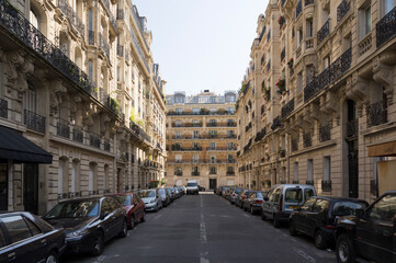 Obraz premium Paris residential street, with Haussmannian facades and parked cars