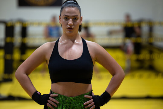 Confident Female Boxer Standing in Ring After Intense Training Session in Gym