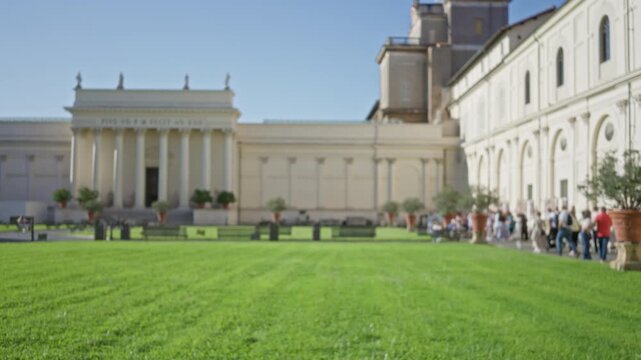 Vatican courtyard blurred bokeh background outdoor with soft shallow focus on green lawn and classical colonnade; background copyspace backplate.