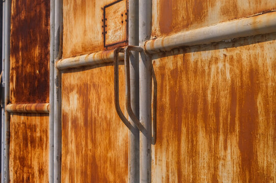 Rusty barbed wire fence on old concrete wall with clear blue sky background for prison or high security area