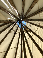 Low angle view of interior of a traditional tipi made of wooden poles and canvas, Rivière-Éternité, Quebec, Canada © Anne Richard