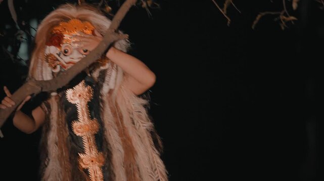 Rangda Holding Tree Branch in Dark Forest