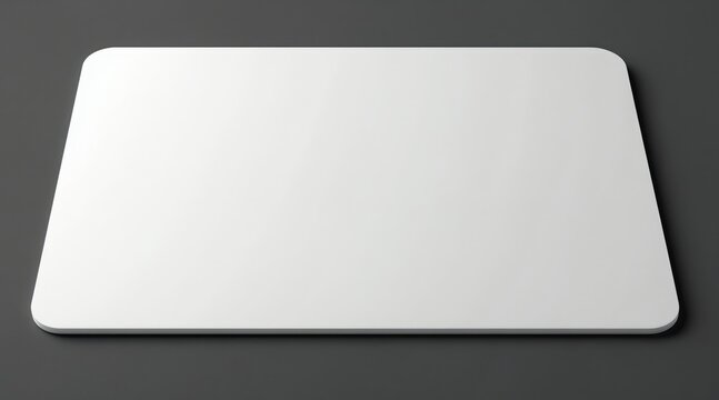 Blank white mousepad on dark gray surface. Ready for custom design logo or graphic. Minimalist workspace mockup for gaming or office computer setup.