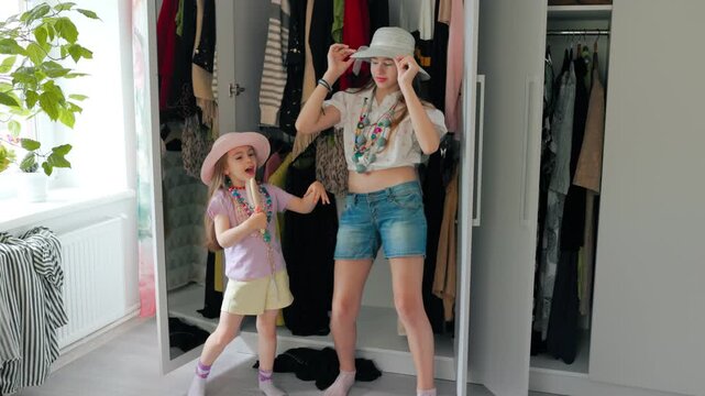 Little child singing into wooden hairbrush while tween sister dances in room.