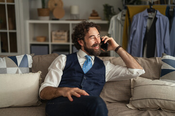 Obraz premium Bearded man smiling talking smart phone at home