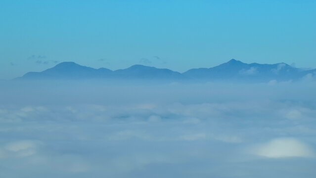 Drone aerial image of a sea of fog over forests with mountain backdrops, highlighting the forest&rsquo;s role in oxygen production, carbon absorption, and biodiversity support. Southeast Asia, Thailand.
