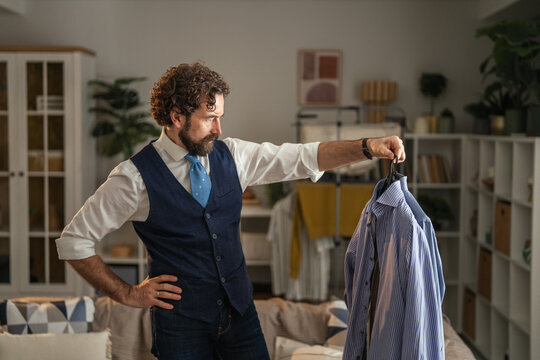 Man choosing outfit getting dressed in sophisticated fashion