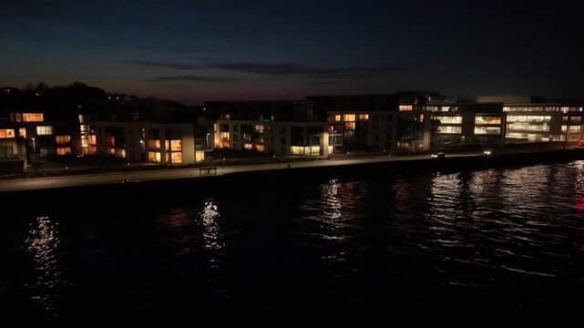 Admiral Park St Peter Port Guernsey.Drone footage over calm sea to Les Banques by night showing Vega Apartments,Martello Court and Dorey Court lit up with lights reflecting in calm sea