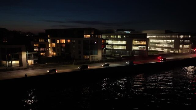 Admiral Park St Peter Port Guernsey.Drone footage of Les Banques by night showing Vega Apartments,Martello Court and Dorey Court lit up at night with lights reflecting in calm sea