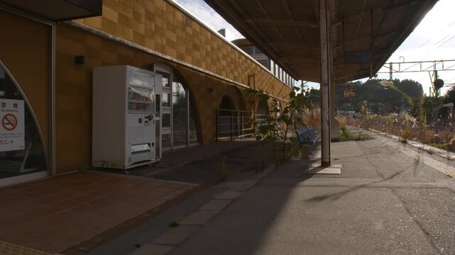 Empty rural train station platform in Japan during golden hour.