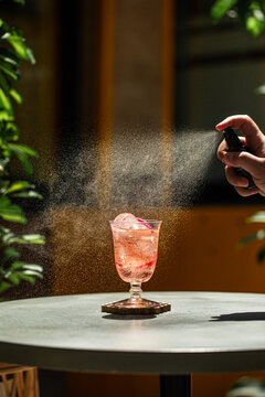 Refreshing tropical cocktail being sprayed with bitters for enhanced aroma and flavor