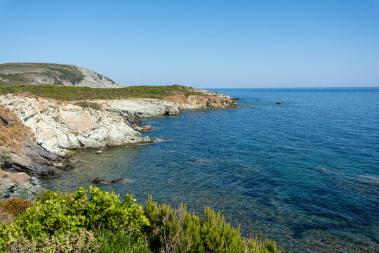 Scenic rocky cliffs lining the coast of North Corsica above the clear Mediterranean Sea