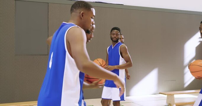 Receiving pass diverse male teammates pivoting and passing basketball around cones