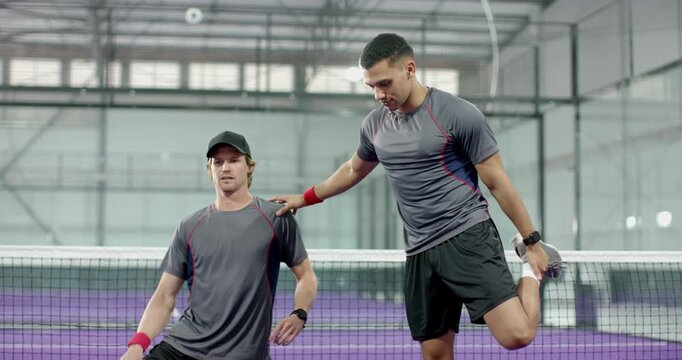 Training partners warming up by lunging, stretching, switching at court net with paddles