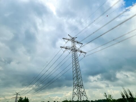 Electricity pylon carrying high voltage power lines under cloudy sky