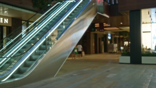 Blurred shopping mall interior with soft bokeh escalator and storefront in shallow focus; background copyspace backplate template.
