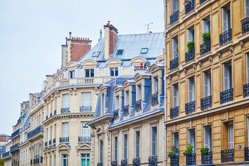 Fototapeta premium Parisian apartment buildings with Haussmann-style facades, mansard roofs, balconies, and elegant historic architecture in France.