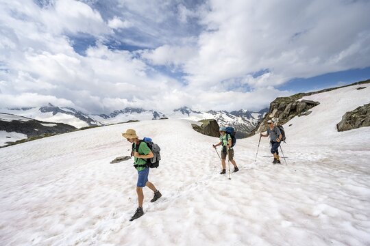 Three mountaineers crossing a snowfield, ascent to the N&ouml;rdliche M&ouml;rchnerscharte, Berliner H&ouml;henweg, Zillertal Alps, Tyrol, Austria