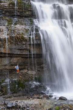 Little hiker in front of large Cascata di Mezzo waterfall, long exposure, Vallesinella, Brenta, Trentino, Italy