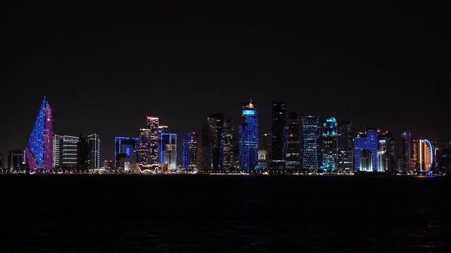 Panoramic night view of the illuminated West Bay skyline in Doha, Qatar.