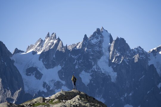 Young man in front of impressive mountain landscape in morning light, pointed rocky icy mountain peaks, Mont Blanc massif, Chamonix-Mont-Blanc, Haute-Savoie, France