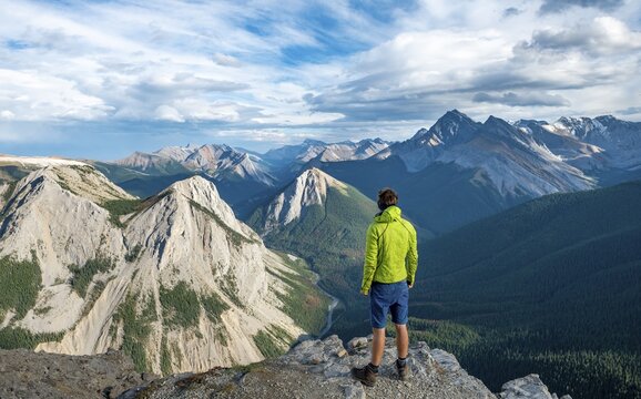 Hiker looking into the distance, mountain landscape with river valley and peaks, peaks with orange sulphur deposits, Overturn Mountain, panoramic view, Nikassin Range, Sulphur Skyline, near Miette Hotsprings, Jasper National Park, Alberta, Canada