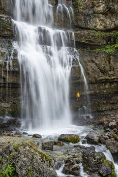 Adventure, Little hiker under large Cascata di Mezzo waterfall, long exposure, Vallesinella, Brenta, Trentino, Italy