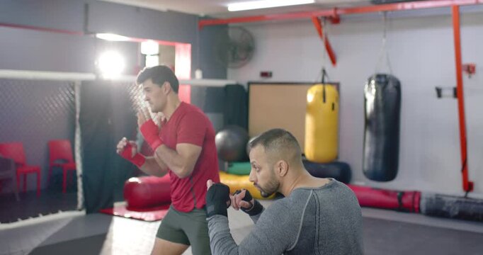 Diverse male sparring partners initiating sparring inside ring practicing jabs, crosses and parries