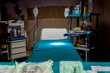 Obraz premium Focused surgery light over operating table in emergency field hospital
