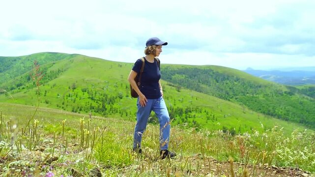 Solo female hiker pauses on Zlatibor trail, turns to take in green slopes and distant peaks. Evokes restorative solo trekking, ecotherapy, and mindful rewards of slowing down in mountain wilderness.