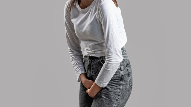 Woman hands holding her crotch. Sick woman hands holding pressing her crotch lower abdomen. Medical or gynecological problems, healthcare concept. Closeup woman hands holding her crotch